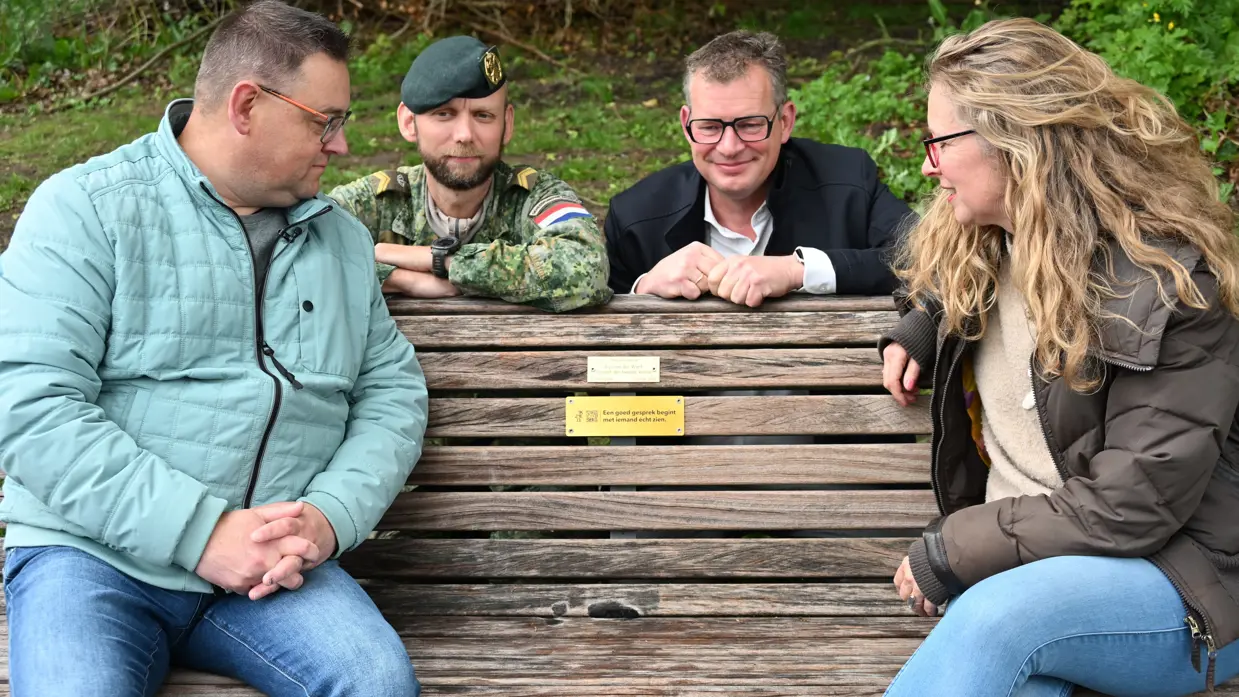 De ouders van Gijs op het bankje. Daarachter Bram en wethouder Wanders. 