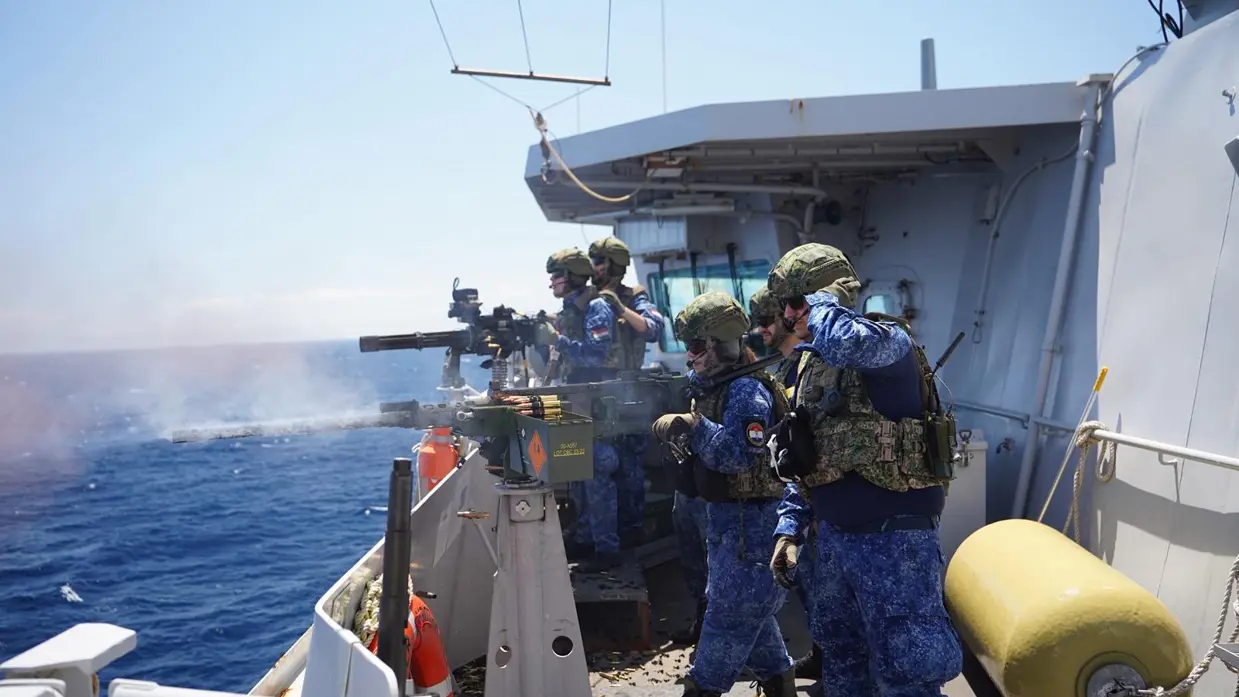 Bemanningsleden vuren met miniguns op een van de dekken van het schip.