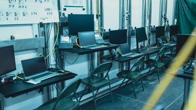 Een rij computerschermen naast elkaar opgesteld.
