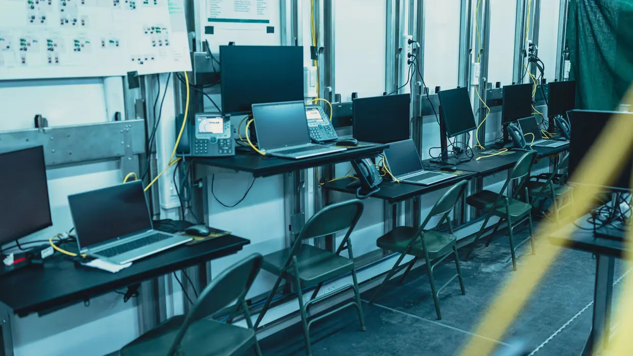 Een rij computerschermen naast elkaar opgesteld.