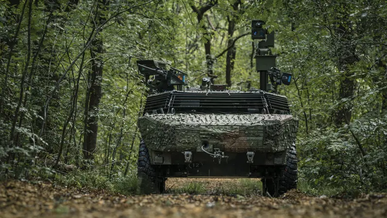 Een militair voertuig midden in het bos. 