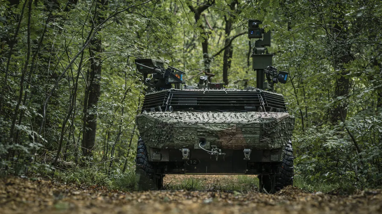 Een militair voertuig midden in het bos. 