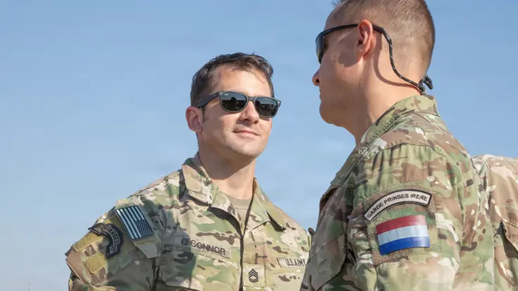 Amerikaanse en Nederlandse militair schudden elkaar de hand.