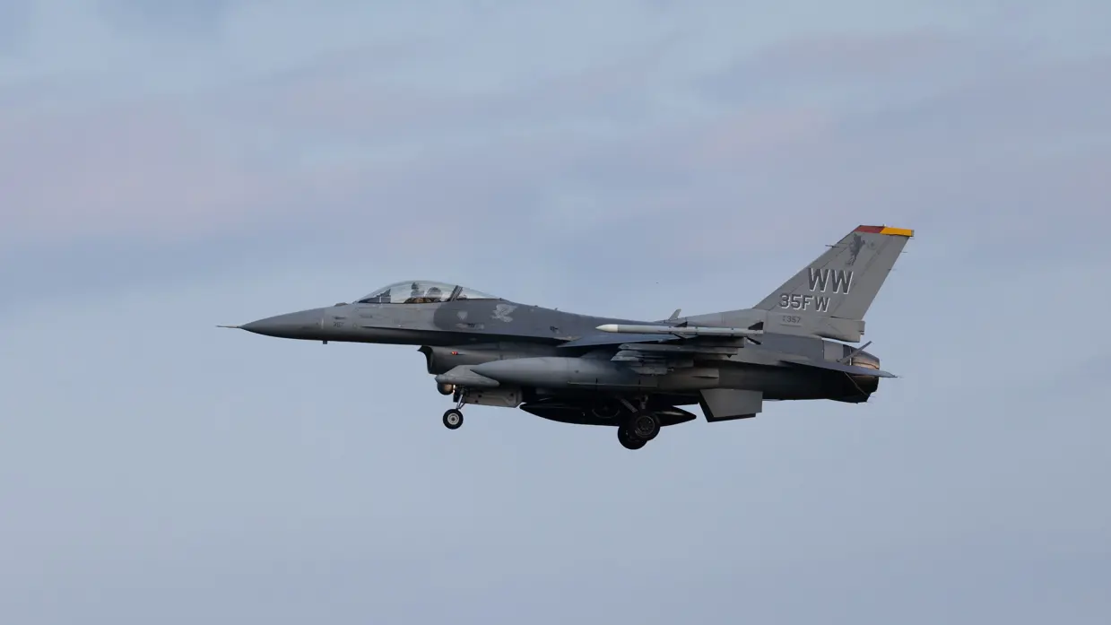 Een F-16 in de landing onder een blauwe lucht. 