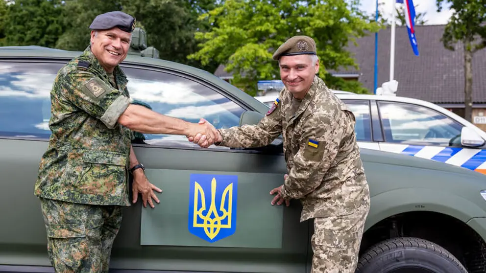 Generaal Onno Eichelsheim schudt andere militair de hand.