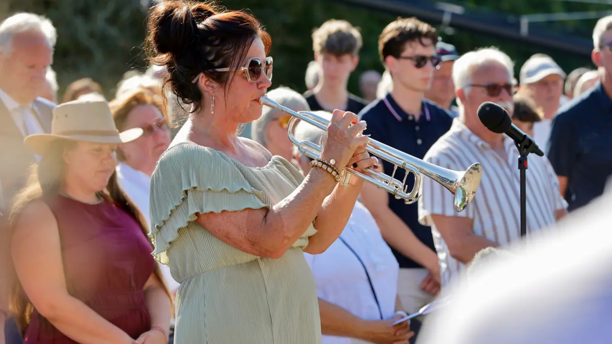 een vrouw in groene jurk speelt op een muziekinstrument.