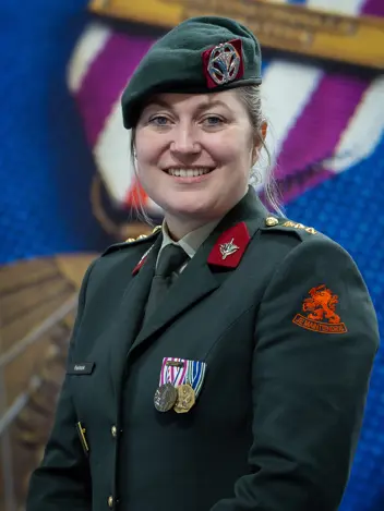 Vriendelijk kijkende militair met baret op en medailles op haar tenue.