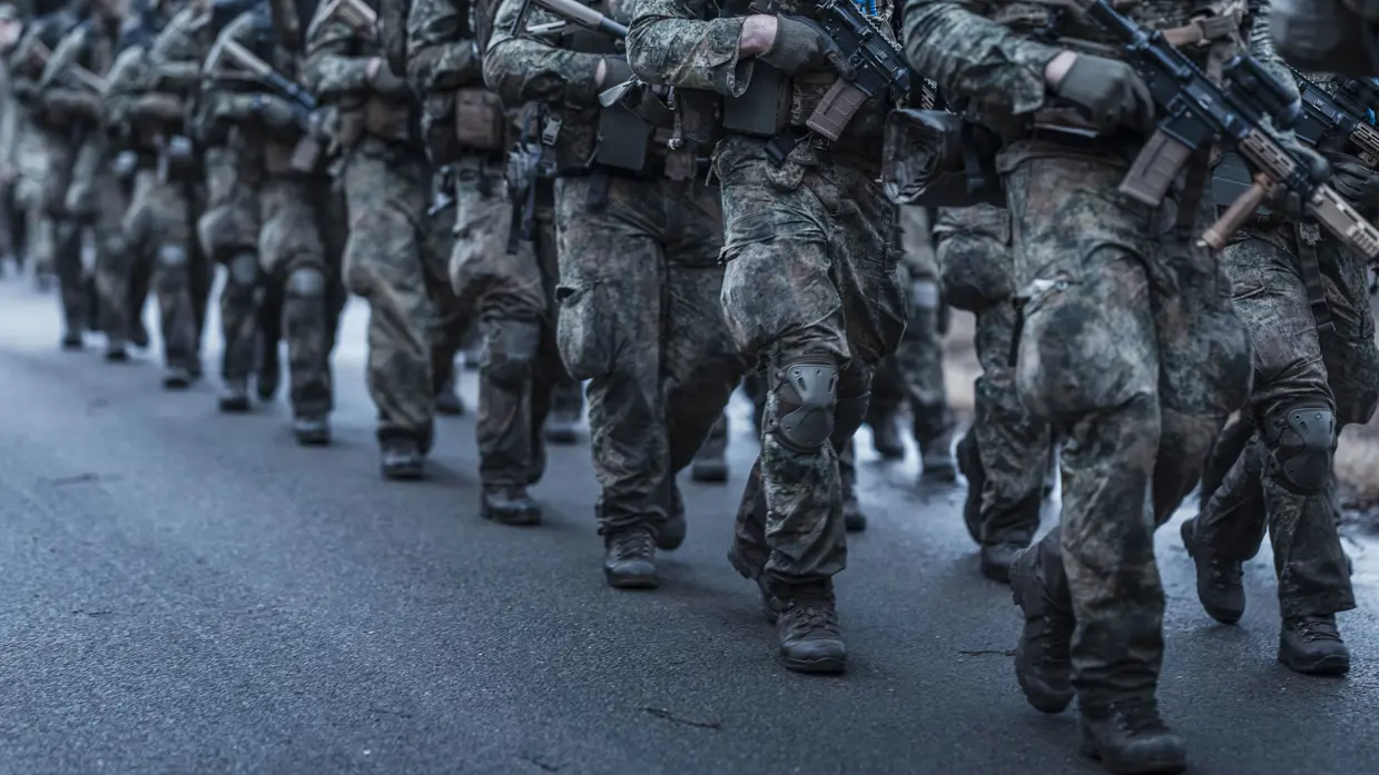 Marcherende militairen, alleen hun benen zijn zichtbaar.