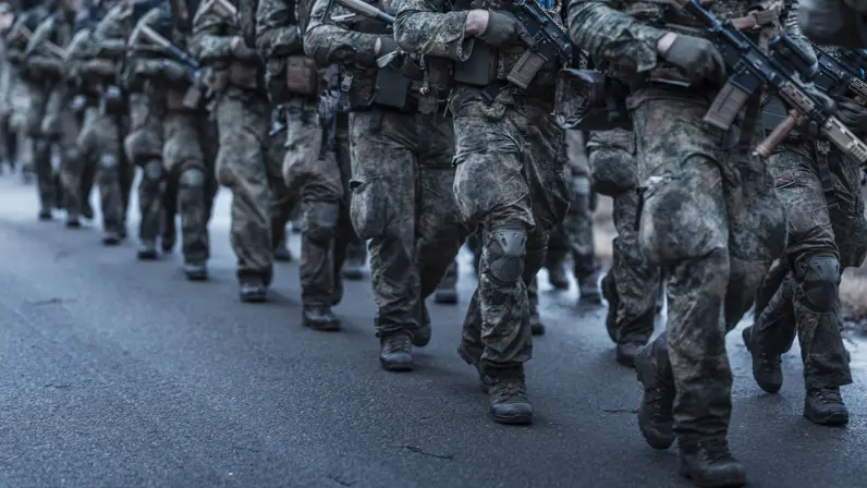 Marcherende militairen, alleen hun benen zijn zichtbaar.