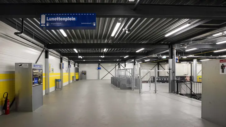 Metrostation met toegangspoortjes en kaartautomaat.