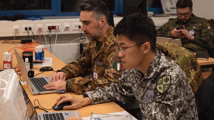 Twee militairen achter een laptop.