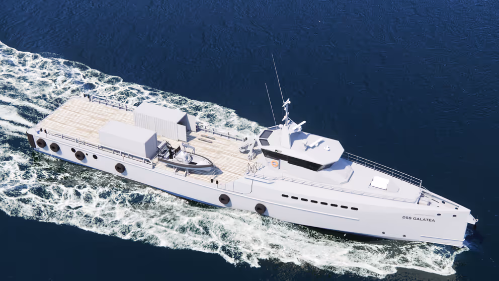 Wit patrouilleschip vaart met snelheid op donkerblauw water.