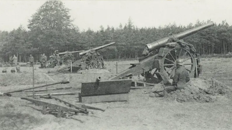 Oude kanonnen op wielen in een open veld, omringd door bomen. Soldaten bedienen de kanonnen, met een rustige, landelijke achtergrond.    