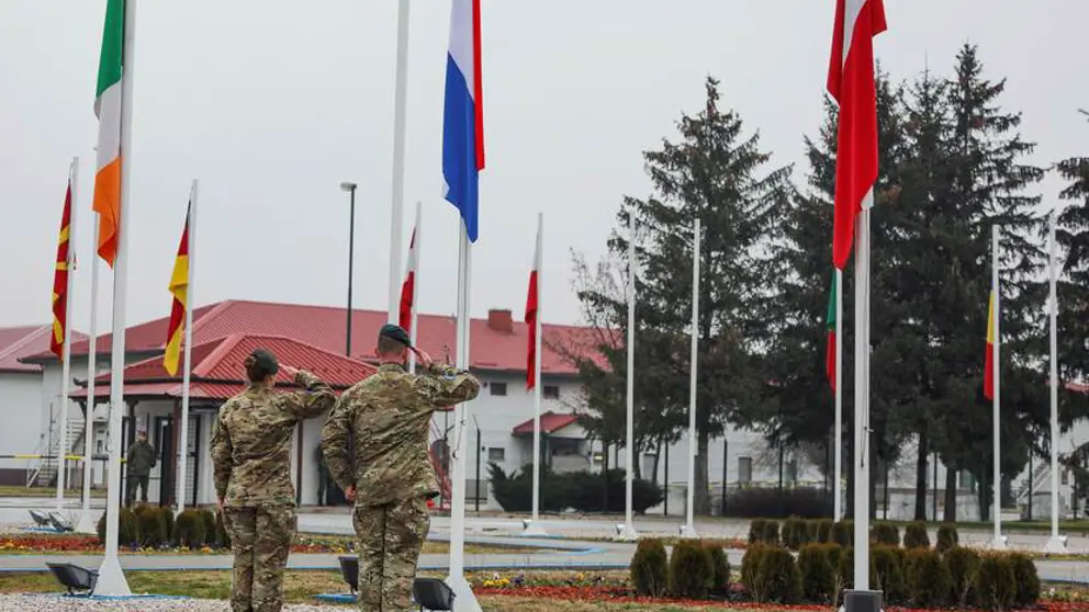 2 Nederlandse militairen salueren voor een rij vlaggen.
