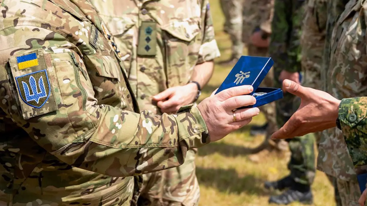 Oekraïense militair overhandigt medaille aan Nederlandse militair. 
