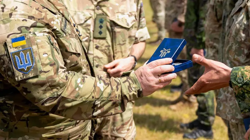 Oekraïense militair overhandigt medaille aan Nederlandse militair. 