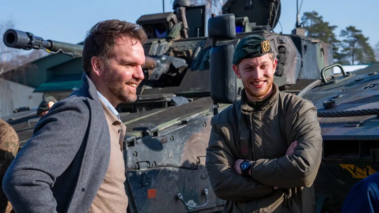 Boswijk staat met de handen in zijn zij en praat met een lachende militair.
