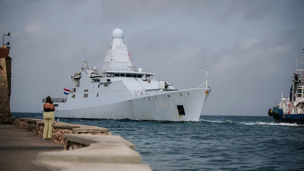 Marineschip komt een baai binnengevaren.