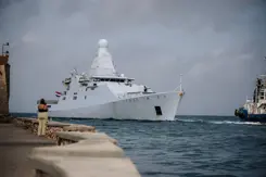 Marineschip komt een baai binnengevaren.