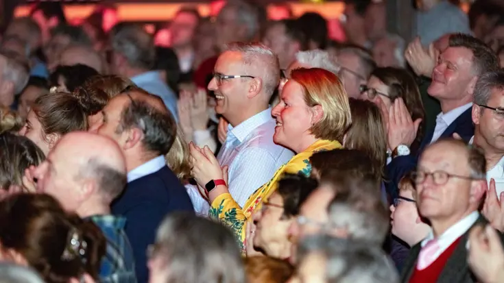 Een groep mensen aan het applaudisseren.