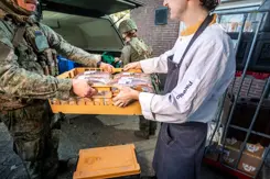 Cateraar levert brood af aan militair.
