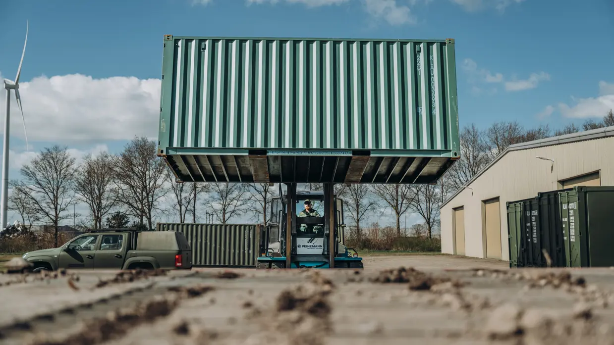 Een heftruck tilt een container op.