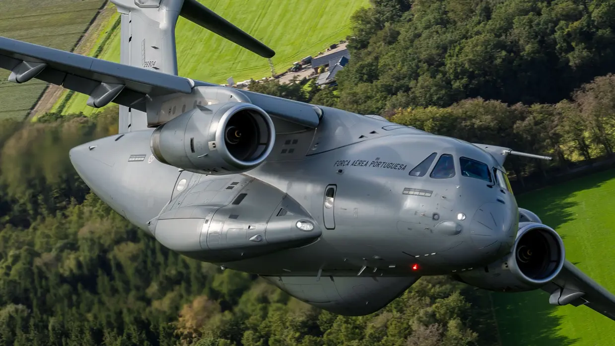 Een C-390 vliegende boven Nederlandse weilanden.
