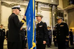 Warnaar op de rug gezien geeft een vlag aan Rear Admiral Joaquin Excagedo.