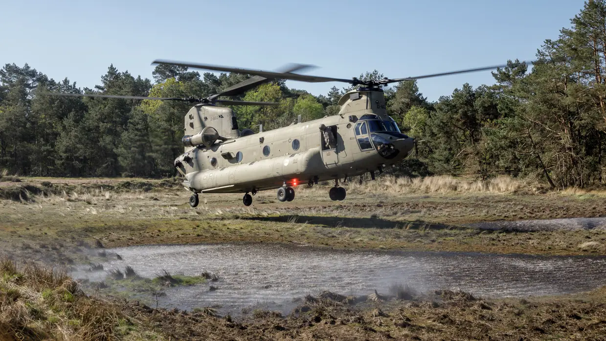 Een Chinook stijgt op tussen twee plassen