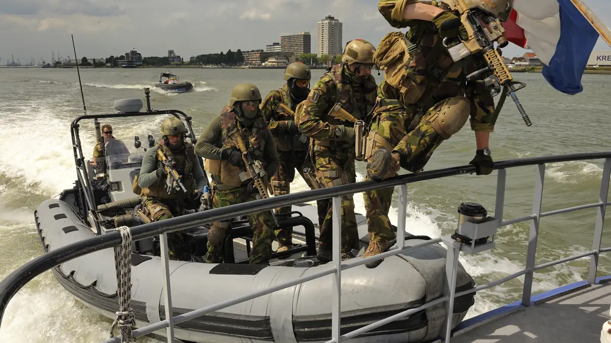Commando's springen van een rubberbootje op een marineschip.