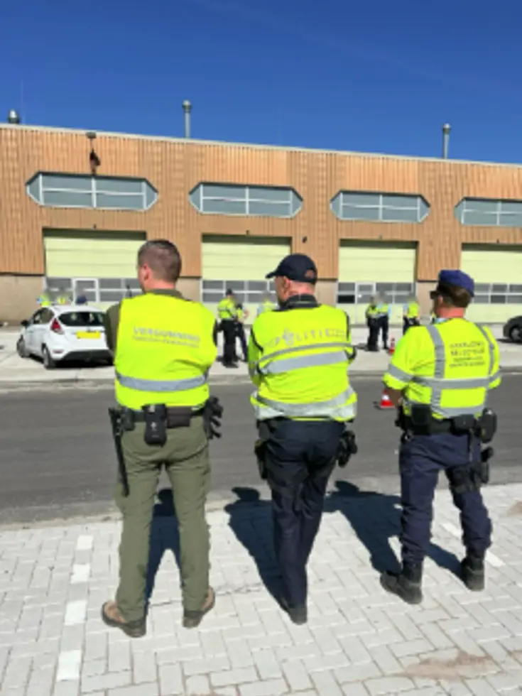 Drie medewerkers van de samenwerkende instanties op de rug gezien.