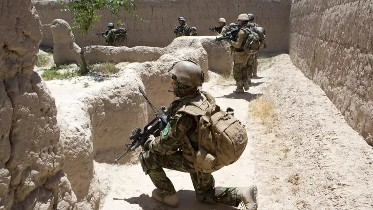 Militairen houden halt tijdens een voetpatrouille in Afghaans dorp.
