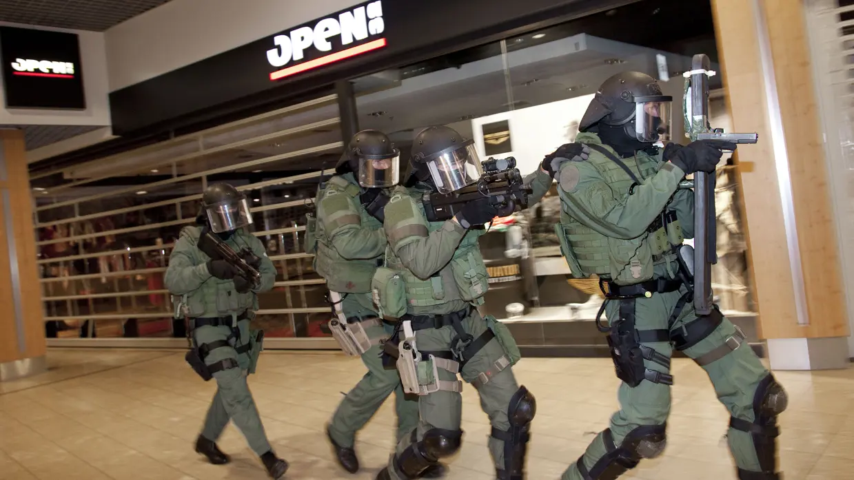 4 leden van de Unit Interventie Mariniers lopen in volledige uitrusting door een winkelcentrum.