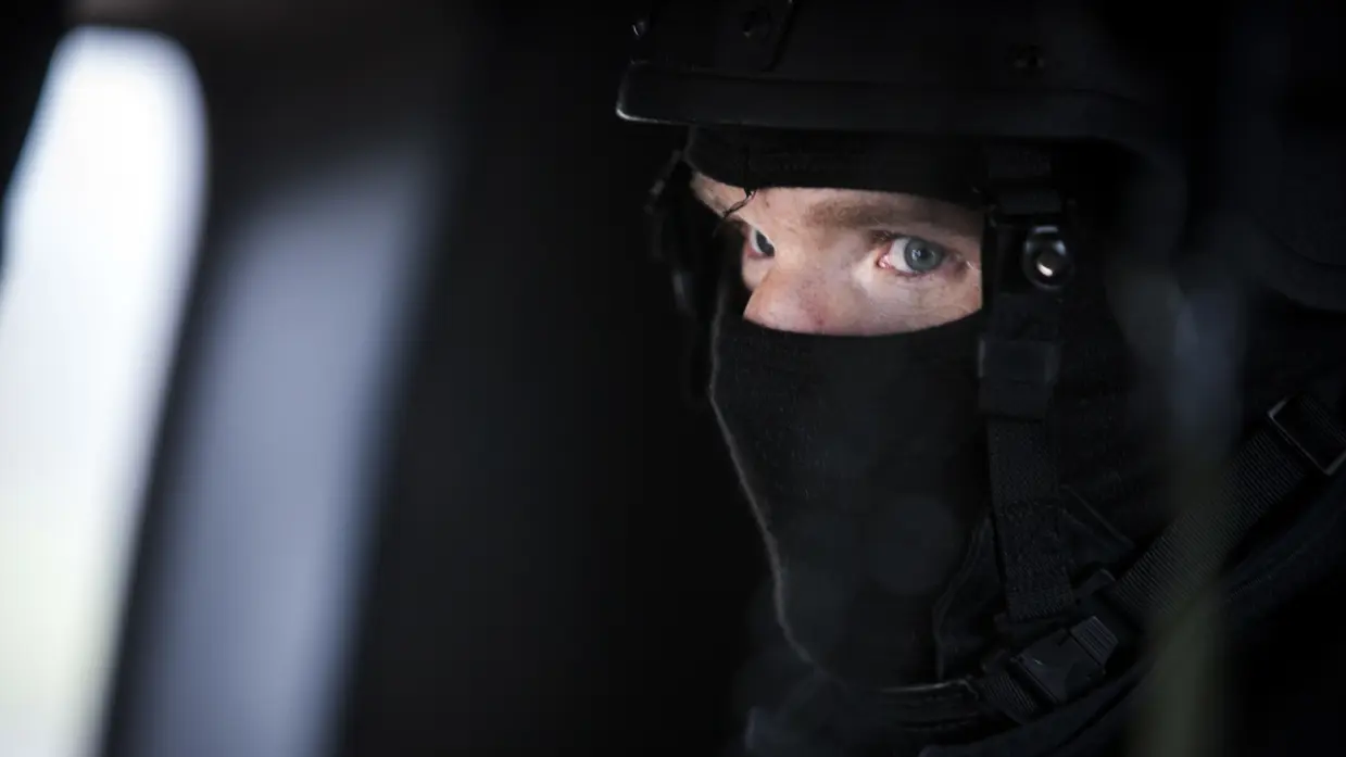 Marechaussee met een balaclava op. 