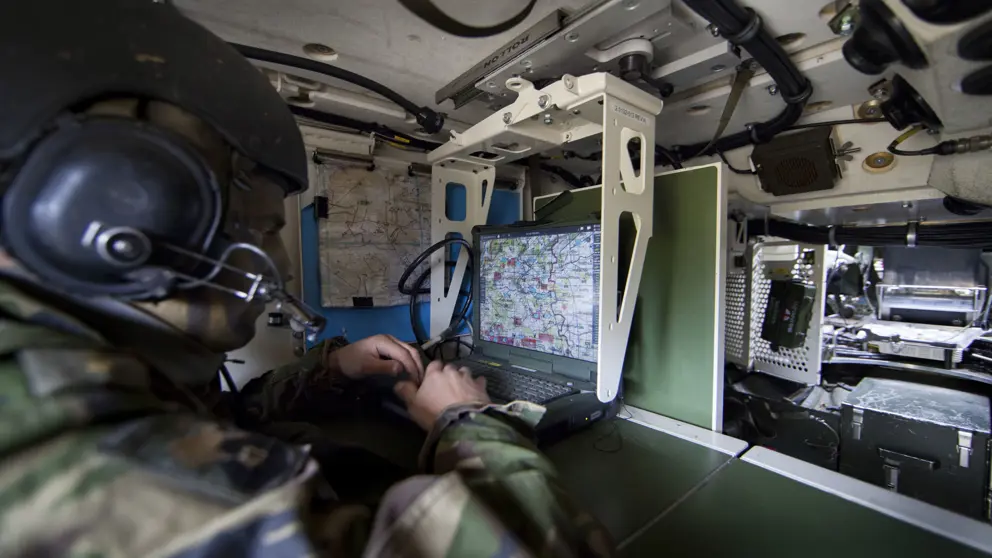 Een militair aan het werk met communicatie-apparatuur.