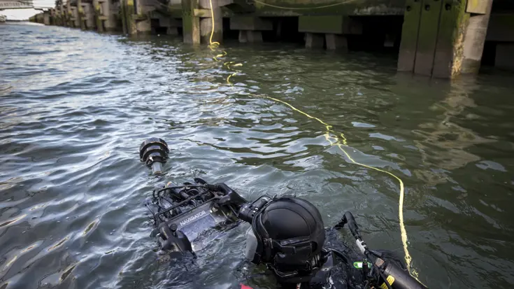 Een duiker van de Maritieme compagnie controleert tijdens een oefening de kades rond de SS Rotterdam op explosieven (2015).