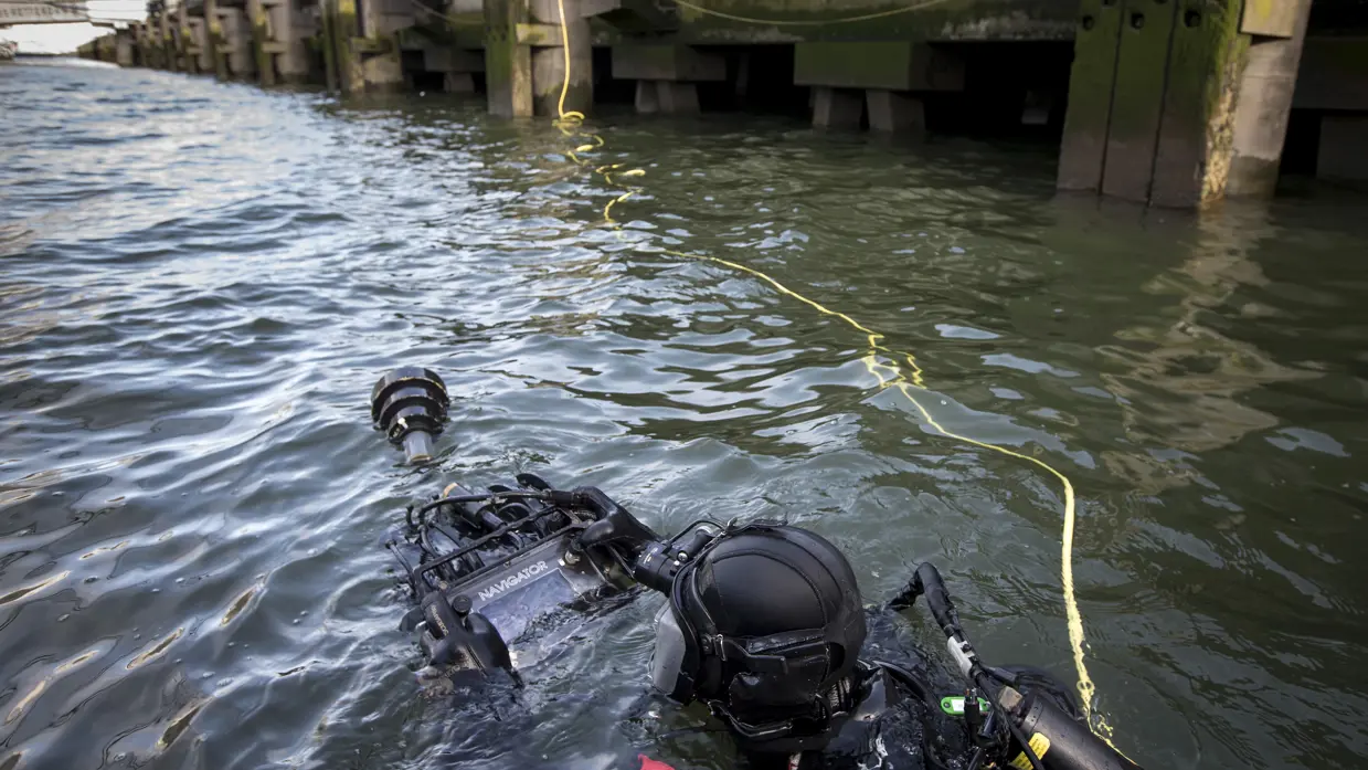 Een duiker van de Maritieme compagnie controleert tijdens een oefening de kades rond de SS Rotterdam op explosieven (2015).