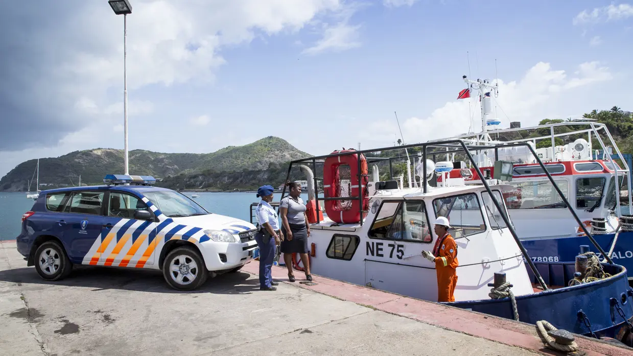 2 marechaussees in een haven in het Caribisch gebied.