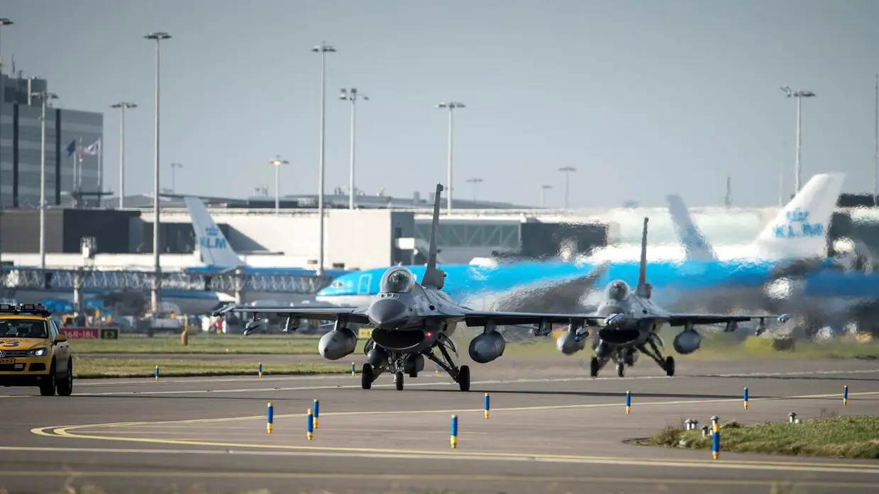 F-16's van de voorzijde gezien met blauwe KLM-toestellen op de achtergrond.