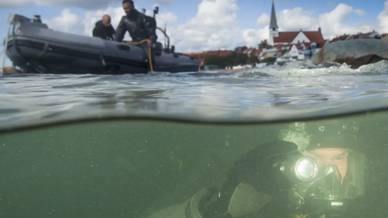 Duiker onder water controleert een haven.