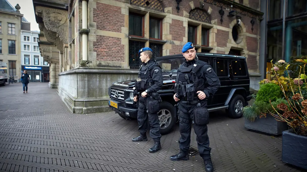 2 marechaussees van Hoog Risico Beveiliging beveiligen een gebouw.