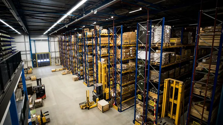 Groot magazijn met stellingen.