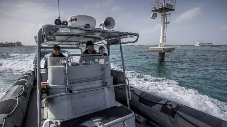 3 leden van de Kustwacht Caribisch Gebied in een boot.