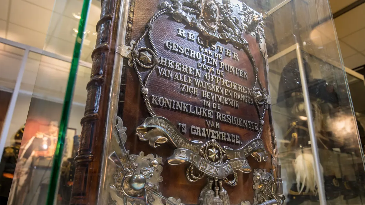 Oud boek met metalen opdruk in vitrine