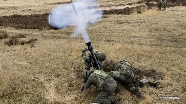 Militairen vuren al liggend op de buik mortieren af.