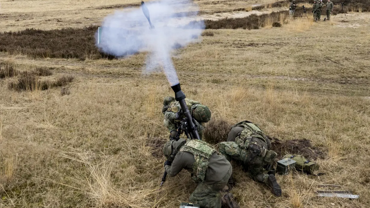 Militairen vuren al liggend op de buik mortieren af.