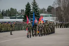 De militairen in Litouwen dragen de vlaggen van de NAVO en de deelnemende landen.