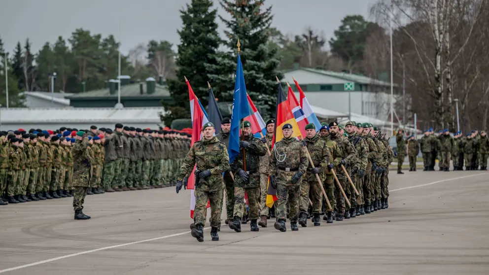 De militairen in Litouwen dragen de vlaggen van de NAVO en de deelnemende landen.