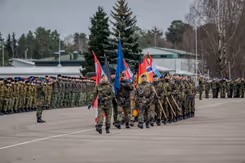 De militairen in Litouwen dragen de vlaggen van de NAVO en de deelnemende landen.