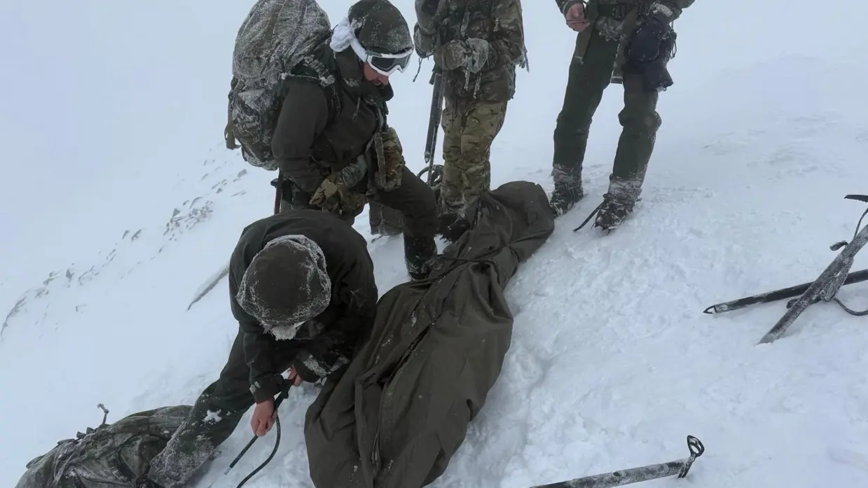 De mariniers in de weer met touwen en een slaapzakhoes. 